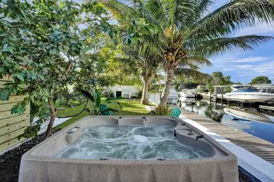 a large hot tub in a yard next to a pool at Hot Tub! Roof Top! Firepit! Boat Dock! in Fort Lauderdale