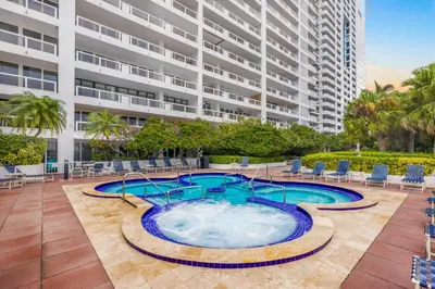 a large building with a swimming pool in front of a building at The Grand Wonder in Miami