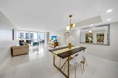 a dining room and living room with a table and chairs at The Grand Wonder in Miami