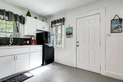 a kitchen with white cabinets and a white door at Welcoming 2-BR apartment - 6 people V1 in Miami