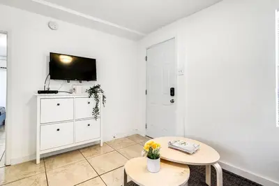a white living room with a table and a tv at Inviting 1-BR apartment for 4 people V2 in Miami