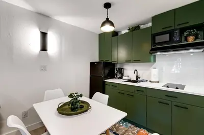 a kitchen with green cabinets and a white table at Captivating 2-BR apartment for 5 people V3 in Miami
