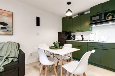 a kitchen with green cabinets and a white table and chairs at Captivating 2-BR apartment for 5 people V3 in Miami