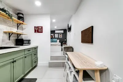 a kitchen with green cabinets and a wooden table at Miami studio apartment, Very centric, Fast Wi-Fi V4 in Miami
