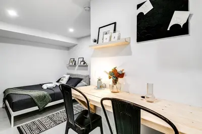 a bedroom with a bed and a desk with chairs at Wonderful Studio Cottage 2 people V5 in Miami