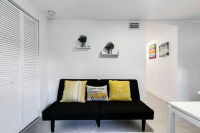 a black couch in a white room with two pillows at Swinging London Studio 3 people V6 in Miami