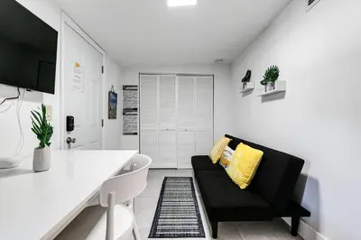a living room with a black couch and yellow pillows at Swinging London Studio 3 people V6 in Miami