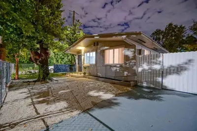 a small house with a fence and a driveway at Wynwood Bungalow Hottub & Pking in Miami