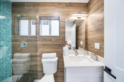 a bathroom with a toilet and a sink and a mirror at 4 Bedroom Holiday Retreat BBQ Marketplace in Miami