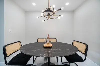a dining room with a black table and a chandelier at 4 Bedroom Holiday Retreat BBQ Marketplace in Miami