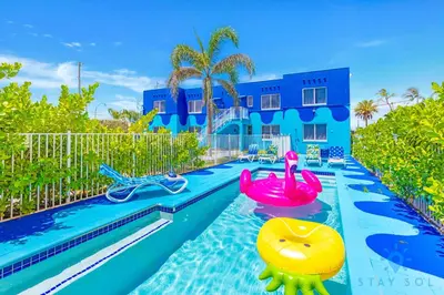 a pool in front of a blue house at Hollywood Broadwalk Haven - Free Parking in Hollywood
