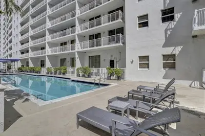 a large apartment building with a swimming pool and chairs at Superb Private unit Perfectly Located In Brickell in Miami