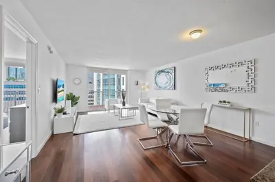 a dining room and living room with a table and chairs at Well Located Unit with parking - Heart Of Brickell in Miami