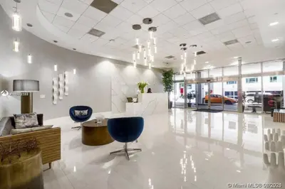 a lobby with two blue chairs and a table at Well Located Unit with parking - Heart Of Brickell in Miami