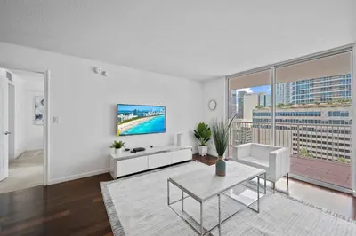 a living room with a tv and a table at Well Located Unit with parking - Heart Of Brickell in Miami
