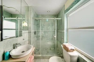 a bathroom with a shower and a sink and a toilet at Magical Beachfront King Escape in Hollywood