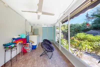 a room with a large window and a chair on a balcony at Hallandale Hideaway in Hallandale Beach