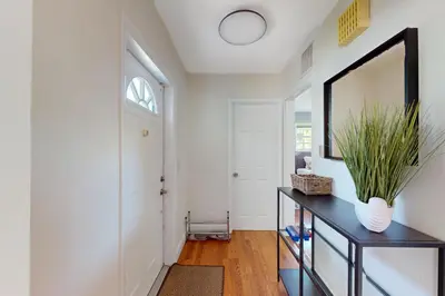 a hallway with a mirror and a table with a plant at Hallandale Hideaway in Hallandale Beach