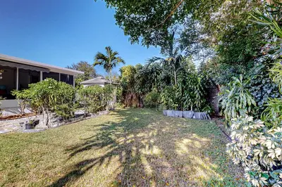 a yard with palm trees and a house at Hallandale Hideaway in Hallandale Beach