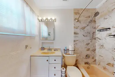 a bathroom with a sink and a toilet and a tub at Hallandale Hideaway in Hallandale Beach