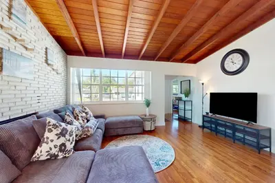 a living room with a couch and a tv at Hallandale Hideaway in Hallandale Beach