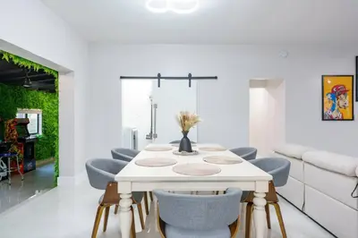 a dining room with a white table and blue chairs at New Miami & Calle Ocho Home with Arcade! in Miami