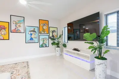 a bathroom with paintings on the wall and a mirror at New Miami & Calle Ocho Home with Arcade! in Miami