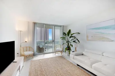 a living room with a white couch and a tv at Spacious Family Escape with Pool & Beach Access in Sunny Isles Beach