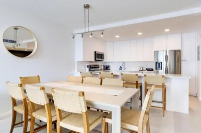 a kitchen and dining room with a white table and chairs at Spacious Family Escape with Pool & Beach Access in Sunny Isles Beach