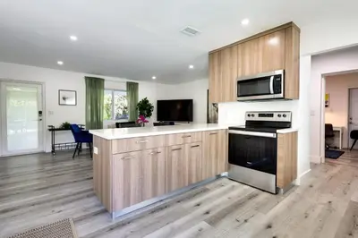 a kitchen with wooden cabinets and a stove top oven at Spacious and Serene Miami Home Walk to Metrorail! in Miami