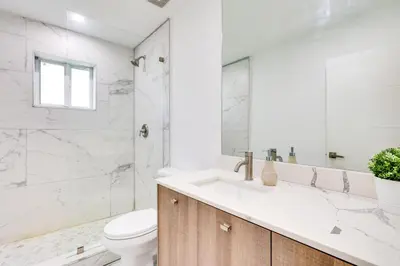 a white bathroom with a toilet and a sink at Spacious and Serene Miami Home Walk to Metrorail! in Miami