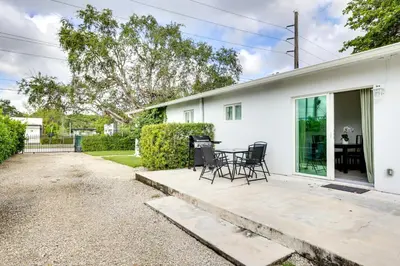 a white house with chairs and a table at Spacious and Serene Miami Home Walk to Metrorail! in Miami
