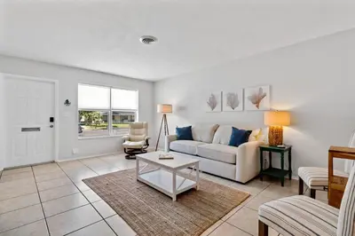 a living room with a couch and a table at Citrus Isles Waterfront Home in Fort Lauderdale