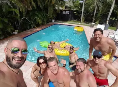 a group of men posing in a swimming pool at Breathtaking Pool Home and Backyard by Wilton Mnrs in Fort Lauderdale