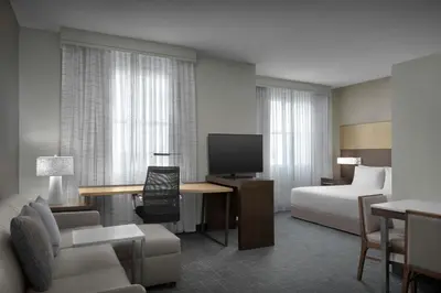 a hotel room with a bed and a desk with a television at Residence Inn by Marriott Fort Lauderdale Airport & Cruise Port in Dania Beach