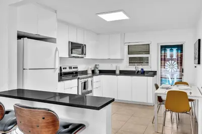 a kitchen with white cabinets and a table and chairs at 3 Bedroom Villa In F Lauderdale Casino & Beach in Fort Lauderdale