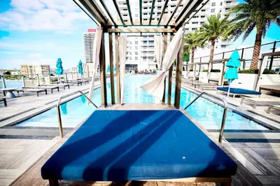 a blue bench sitting next to a swimming pool at Breathtaking 35th Floor 1 BDR in Hyde Beach House in Hollywood