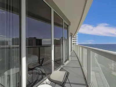 a balcony with chairs and the ocean on a building at WVR Vacation Residences 709 in Fort Lauderdale