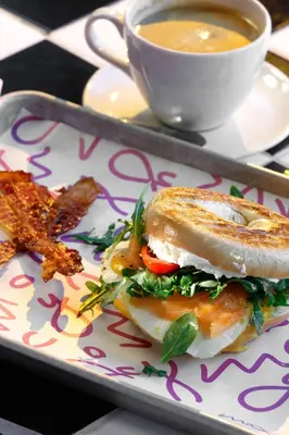 a sandwich on a plate with a cup of soup at Moxy Miami Wynwood in Miami