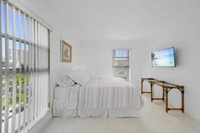 a white bedroom with a bed and a window at Le Cartier Sunny Isles Ocean Paradise in Sunny Isles Beach