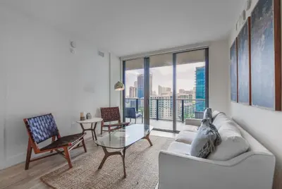 a living room with a couch and a glass table at Unwind in Your Amazing City View Apartment in Miami