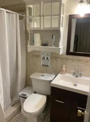 a bathroom with a white toilet and a sink at Beds & Sheets DOWNTOWN in Miami