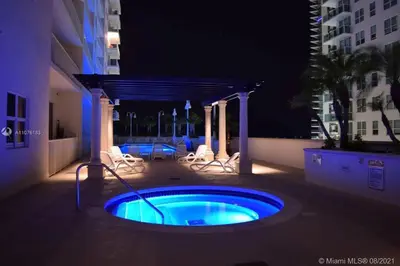 a swimming pool with chairs and a gazebo at night at Miami Brickell 3 Bedrooms high ceiling loft in Miami