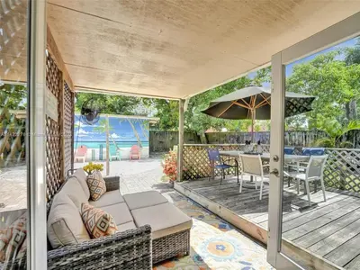 an outdoor patio with a couch and an umbrella at Tropical Oasis - BBQ and Beach-Inspired Nook in Fort Lauderdale