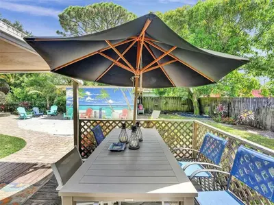 a table with a large umbrella on a patio at Tropical Oasis - BBQ and Beach-Inspired Nook in Fort Lauderdale