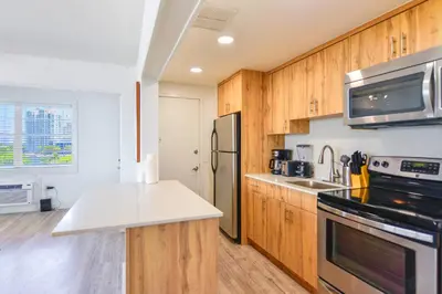 a kitchen with wooden cabinets and a stainless steel refrigerator at Front Bay & Unique Stay for a Relaxing Experience in Miami Beach