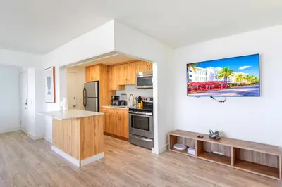 a kitchen with white walls and wooden cabinets at Front Bay & Unique Stay for a Relaxing Experience in Miami Beach