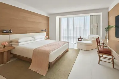 a bedroom with a large bed and a chair at The Miami Beach EDITION in Miami Beach