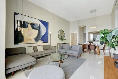 a living room with a large painting of a woman wearing sunglasses at Brickell Oasis 5BR Free Parking Pool Gym and More in Miami