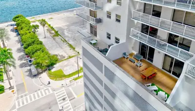 an aerial view of a building with the ocean in the background at Brickell Oasis 5BR Free Parking Pool Gym and More in Miami
